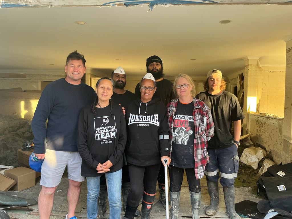 people lined up in a flood damaged home