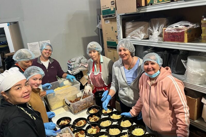 six women in a kitchen preparing food